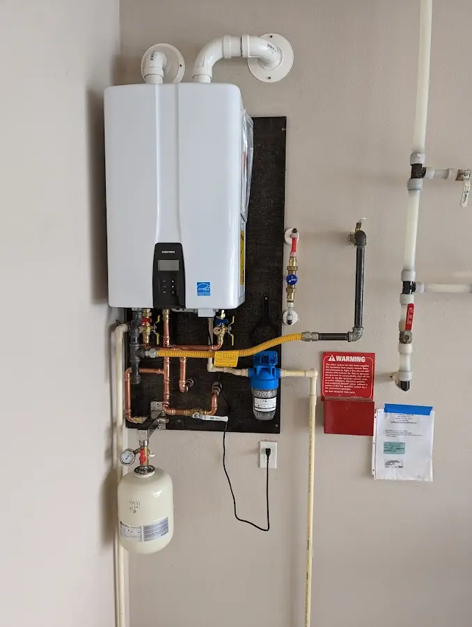 Professional plumber installing copper piping in a Plainville home